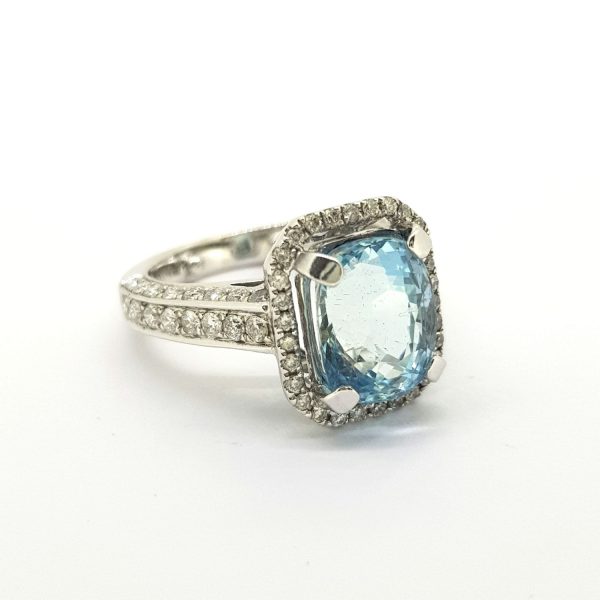 Aquamarine and Diamond Cluster Dress Ring; central 3.49ct oval aquamarine within an emerald shaped diamond-set surround with diamond set shoulders, in 18ct white gold