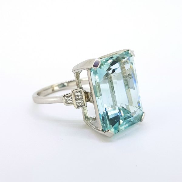 Aquamarine Cocktail Ring with Diamond Shoulders; 17.00 carat emerald-cut aquamarine, with three princess-cut diamonds to each shoulder, in 18ct white gold