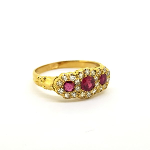 Ruby and Diamond Three Stone Cluster Ring; striking triple cluster ring featuring three round faceted rubies with diamond surrounds, in 18ct yellow gold.