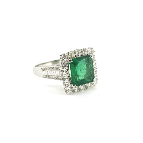 Octagonal Cut Emerald and Diamond Cluster Ring; 2.61ct octagonal step-cut emerald surrounded by diamonds, baguette and brilliant-cut diamond-set shoulders, in 18ct white gold