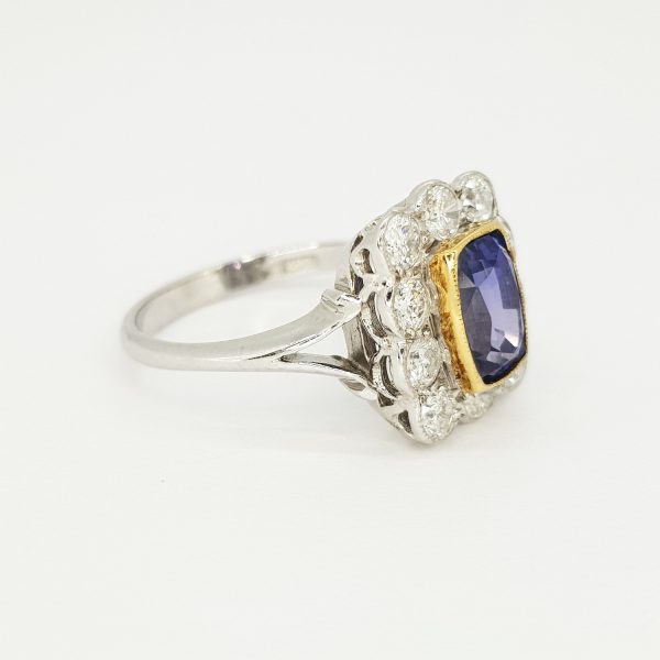Natural Sapphire and Diamond Cluster Ring; 2.16 carat oval faceted natural sapphire surrounded by 0.98cts diamonds, in 18ct white gold with split shoulders