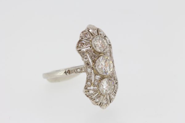 Vintage Three Stone Diamond Plaque Ring; 1.00 carat total, three central diamonds set within a pierced diamond-set tapered navette shaped surround, in 18ct white gold