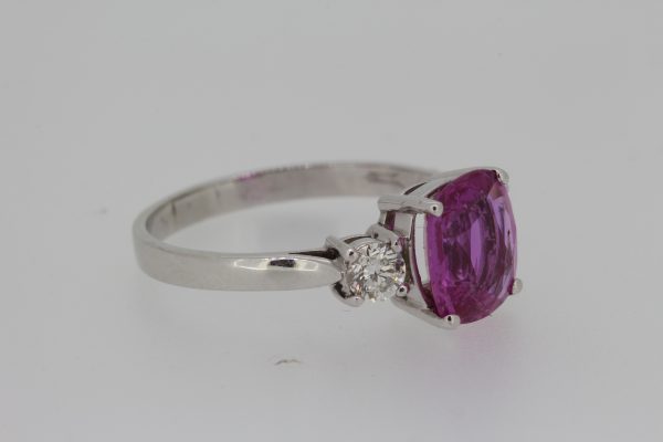 Cushion Cut Pink Sapphire and Diamond Three Stone Ring; 2.80 carat cushion-cut pink sapphire flanked by 0.40cts brilliant -cut diamonds, four-claw set in platinum