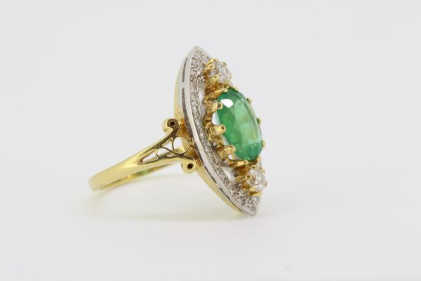 Emerald and Diamond Marquise Shaped Navette Cluster Ring; central oval emerald within an open marquise-shaped border of diamonds with two main diamonds top and bottom, in 18ct yellow gold with split scrolled shoulders