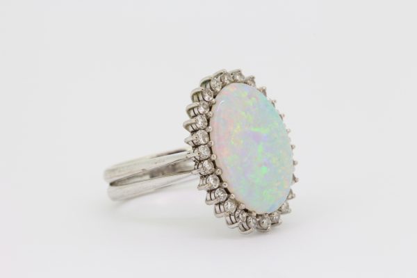 Vintage Opal and Diamond Oval Cluster Ring; central oval cabochon-cut white precious opal surrounded by 0.80cts diamonds, in 18ct white gold with double shank