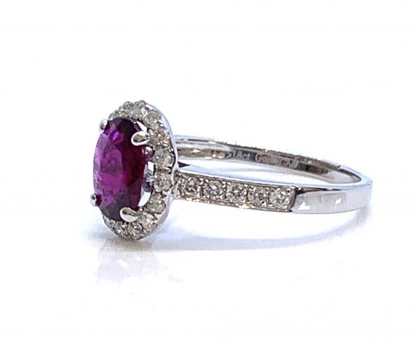 Burma Ruby and Diamond Cluster Ring; central 1.11ct oval faceted Burmese ruby with no indication of heat treatment set within a diamond halo, with diamond set shoulders, in 18ct white gold