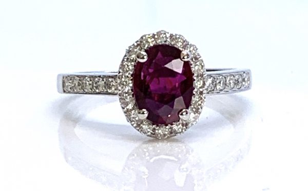 Burma Ruby and Diamond Cluster Ring; central 1.11ct oval faceted Burmese ruby with no indication of heat treatment set within a diamond halo, with diamond set shoulders, in 18ct white gold
