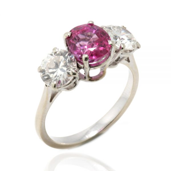 Natural Pink Sapphire and Diamond Three Stone Ring; central 1.50ct natural pink sapphire flanked by 2cts round brilliant-cut diamonds, all claw set in platinum