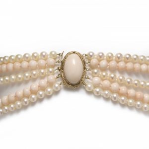 Vintage Coral and Cultured Pearl Five Row Necklace; comprised of three rows of 6mm white cultured pearls and two rows of 8mm round coral beads, a cabochon coral clasp, in 18ct yellow gold, Circa 1970