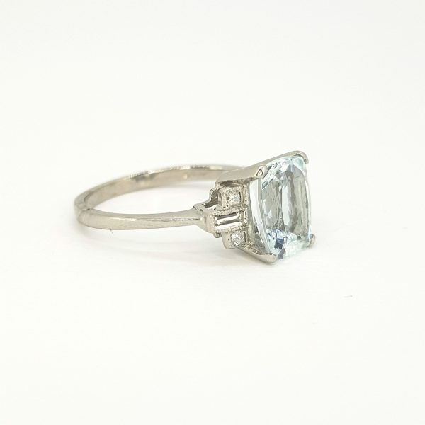 Aquamarine and Diamond Dress Ring in Platinum; central 2.20ct oval cushion-shaped aquamarine flanked by 0.20cts baguette-cut diamond set shoulders