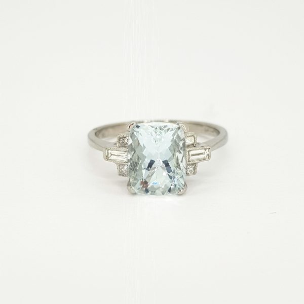 Aquamarine and Diamond Dress Ring in Platinum; central 2.20ct oval cushion-shaped aquamarine flanked by 0.20cts baguette-cut diamond set shoulders