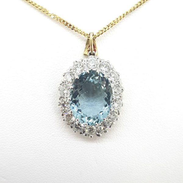 Aquamarine and Diamond Oval Cluster Pendant; 6.61ct oval-cut aquamarine claw set within a 1.50ct brilliant-cut diamond surround, in 18ct gold