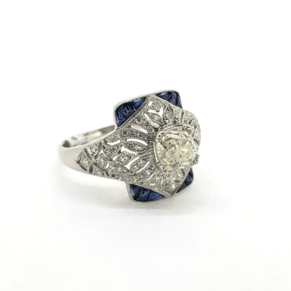 0.80ct Old Cut Diamond and Calibre Sapphire Dress Ring; central 0.80 carat old cut diamond within a diamond-set pierced surround, accented with calibre-cut sapphires, in platinum