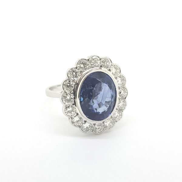 Sapphire and Diamond Oval Cluster Ring; central 5.67ct oval sapphire surrounded by 1.16cts sparkling diamonds, H colour, collet set in 18ct white gold