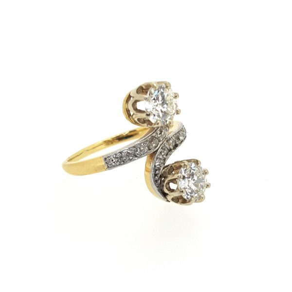 Antique Edwardian Diamond Two Stone Crossover Ring, 1.50 carat total, featuring two principal diamonds connected by diamond-set swirled shoulders, in 18ct yellow gold