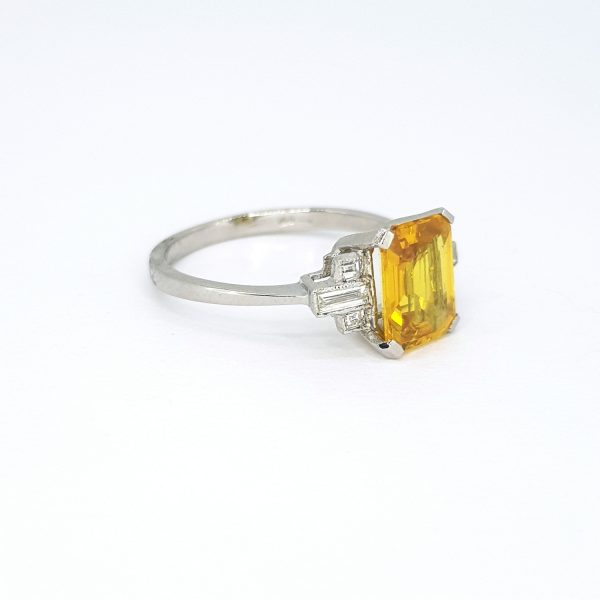 Yellow Sapphire and Diamond Ring in Platinum; central 2.10 carat emerald-cut yellow sapphire flanked by baguette and princess cut diamonds
