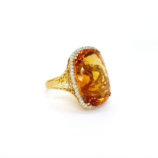 Citrine and Diamond Cluster Cocktail Ring; impressive large 45ct oval cushion-shaped citrine with a delicate 0.40ct diamond surround, in 18ct yellow gold with pierced under-gallery and shoulders