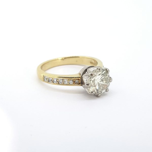 1.71ct Diamond Solitaire Engagement Ring in 18ct Yellow Gold; featuring a 1.71 carat round brilliant-cut diamond, claw set in a high white gold crown collet, accented by channel set diamond shoulders in 18ct yellow gold