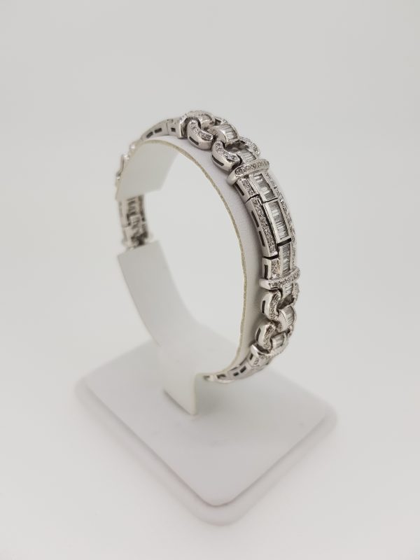 Art Deco Style Diamond Bracelet, 10 carat total; central row of baguette-cut diamond-set articulated links, flanked by a fluid geometric diamond-set surround, in 18ct white gold