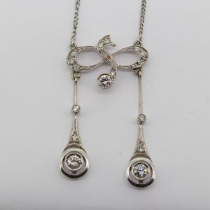 Antique Edwardian Diamond Negligee Pendant Necklace; diamond-set fluid design suspending two diamond set pendants, to a platinum chain, Circa 1910