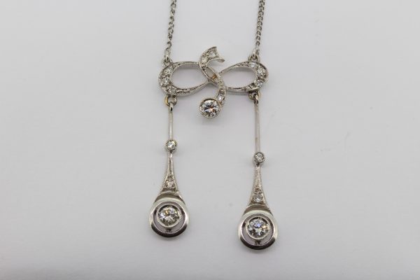 Antique Edwardian Diamond Negligee Pendant Necklace; diamond-set fluid design suspending two diamond set pendants, to a platinum chain, Circa 1910