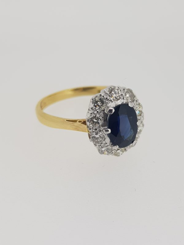 Vintage Sapphire and Diamond Cluster Ring; central oval sapphire within a diamond surround, in 18ct gold, Circa 1970s