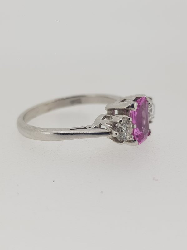 Emerald Cut Pink Sapphire and Diamond Three Stone Ring; central 1.01ct emerald-cut pink sapphire flanked by 0.40cts brilliant-cut diamonds, in 18ct white gold