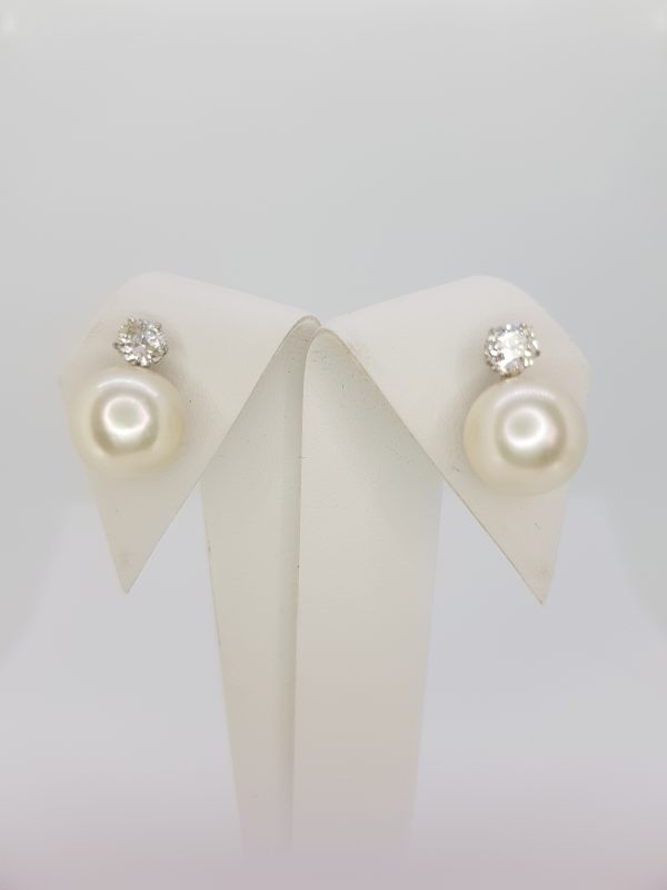 Pearl and Diamond Earrings; each earring features a cultured pearl topped with a diamond stud, in 18ct white gold