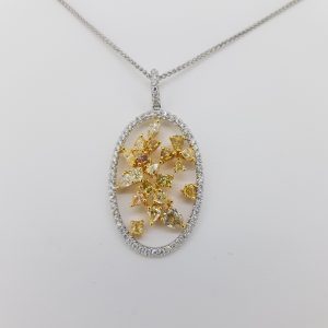 Fancy Yellow and White Diamond Pendant; featuring fancy yellow diamonds in a floral open design surrounded by an oval halo of white diamonds