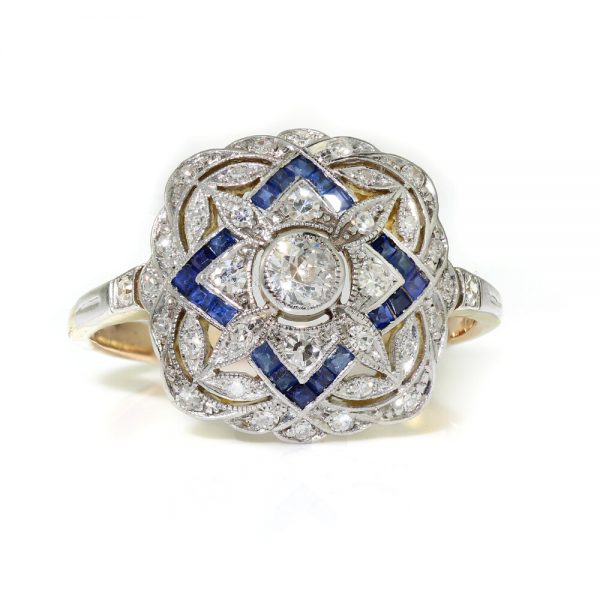 Art Deco Sapphire and Old Cut Diamond Cluster Dress Ring; pierced platinum mount set with 0.50cts old cut diamonds and 0.24cts princess-cut sapphires, with later added 18ct gold shank