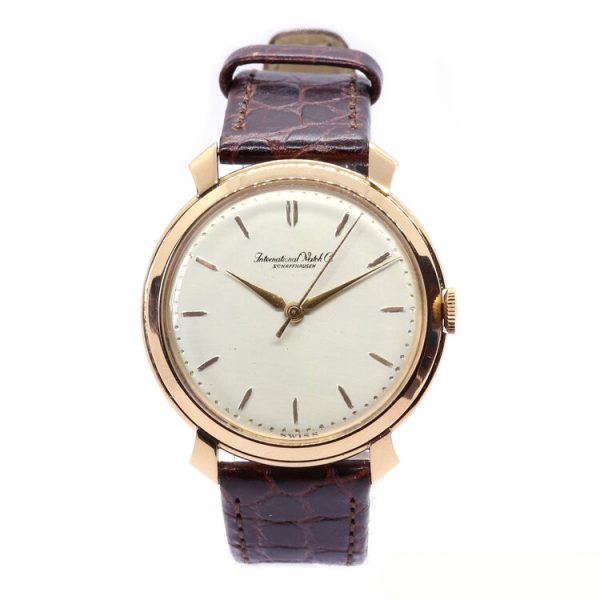 IWC Vintage 18ct Rose Gold 36mm Manual Wristwatch; round silvered dial with baton hour markers and gold hands, on a brown leather strap, Circa 1950s