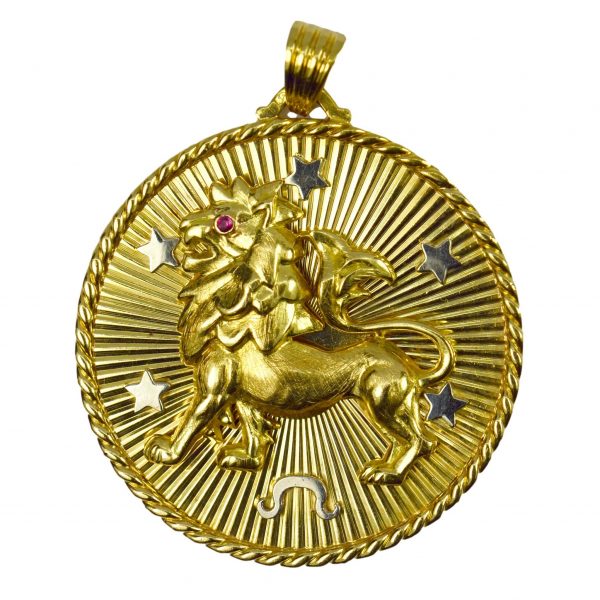 French 18ct Yellow Gold Zodiac Leo Pendant Charm; depicting a three-dimensional lion with ruby eye and white gold stars, initial 'M' surrounded by sunburst pattern to reverse
