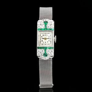 Art Deco Diamond, Emerald and Platinum Manual Cocktail Watch by Drecier and Co; set with 0.64cts emeralds and 0.90cts old-cut diamonds, Circa 1920s