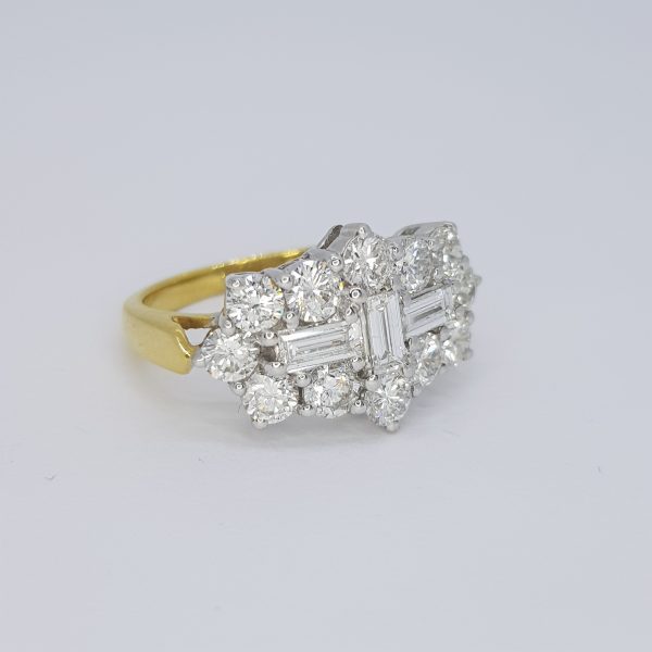 Baguette and Brilliant Cut Diamond Cluster Ring; three central baguette-cut diamonds within a brilliant-cut diamond surround, 18ct yellow gold