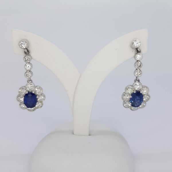 Sapphire and Diamond Cluster Drop Earrings; featuring 2.40cts sapphires surrounded by diamond and suspended from diamond set studs via diamond set drops, 2ct total, in 18ct white gold