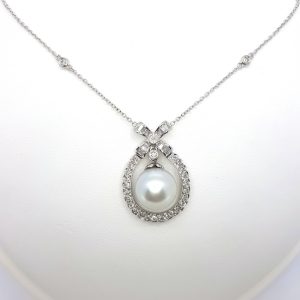 South Sea Pearl and Diamond Cluster Drop Pendant; 11mm white South Sea pearl suspended within a 1.40ct diamond surround, in 18ct white gold