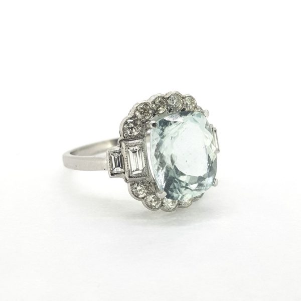 Aquamarine and Diamond Cluster Ring; 4.50 carat cushion-shaped aquamarine within a brilliant and baguette-cut diamond surround, mounted in platinum