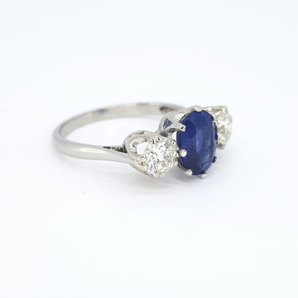 Sapphire and Diamond Three Stone Ring in Platinum; central 1.71ct oval sapphire flanked by 0.60cts brilliant-cut diamonds
