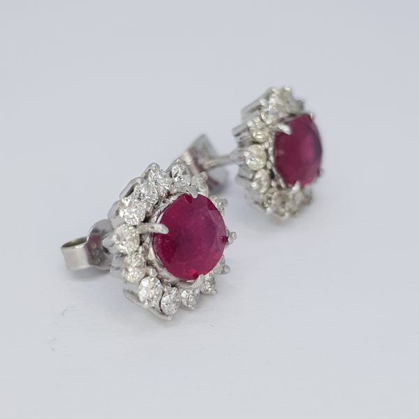 Ruby and Diamond Oval Cluster Stud Earrings; featuring oval faceted rubies surrounded by diamonds, claw-set and mounted in 18ct white gold