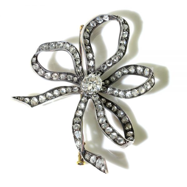 Antique Old Cut Diamond Bow Brooch; set with 6.55 carats of old-cut and rose-cut diamonds, in silver and 15ct gold, Circa 1830s