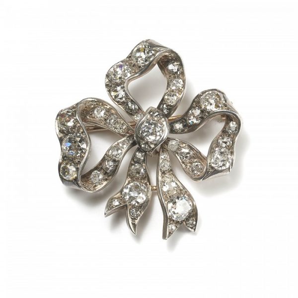 Antique Victorian Old Cut Diamond Bow Brooch; set with 9cts of round and cushion shaped old-cut diamonds, in silver upon gold, Circa 1890