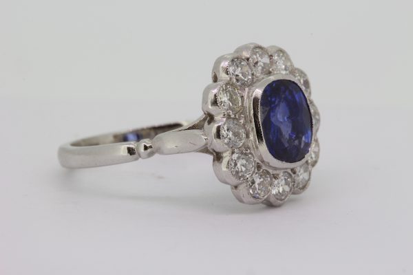 Cushion Cut Sapphire and Old Cut Diamond Floral Cluster Ring; 2.25ct cushion-cut fine colour sapphire, collet set and surrounded with 1.05cts old cut diamonds, in platinum