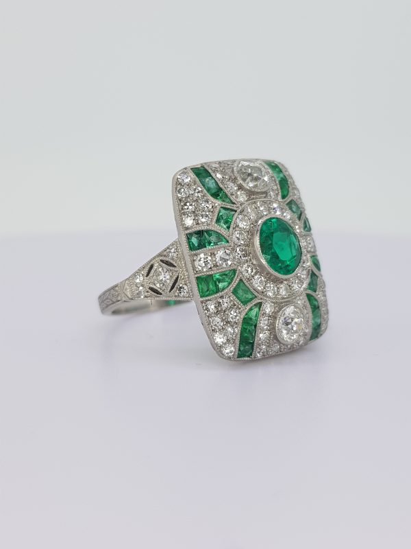 Art Deco Style Emerald and Diamond Cluster Dress Ring; round faceted emerald surrounded by 1.56cts brilliant diamonds and calibre emeralds, in 18ct white gold