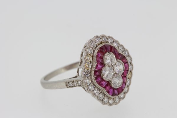 Ruby and Diamond Cluster Dress Ring in Platinum; four central brilliant-cut diamonds within a calibre-cut ruby surround and an outer diamond border