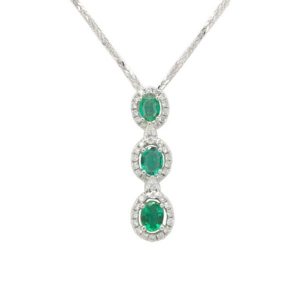 Emerald and Diamond Triple Cluster Pendant; featuring three perpendicular set oval faceted emeralds surrounded by diamonds, spaced with pear-shaped diamonds, in 18ct white gold. Emeralds 0.54cts, Diamonds 0.36cts