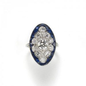 Art Deco Style Sapphire and Old Cut Diamond Cluster Plaque Ring; central old European-cut diamond within a diamond surround and outer calibre sapphire border, in platinum
