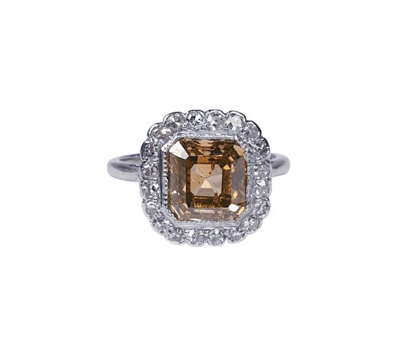 Asscher Cut Fancy Diamond Cluster Ring; central 2.76ct golden Asscher cut diamond set within a surround of 0.20cts old cut diamonds, in 18ct gold and platinum, Circa 1940