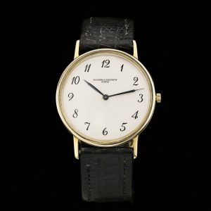 Vintage Vacheron Constantin 18ct Yellow Gold 33mm Manual Watch, white dial with black Arabic numerals, on a black leather strap. Circa 1960s