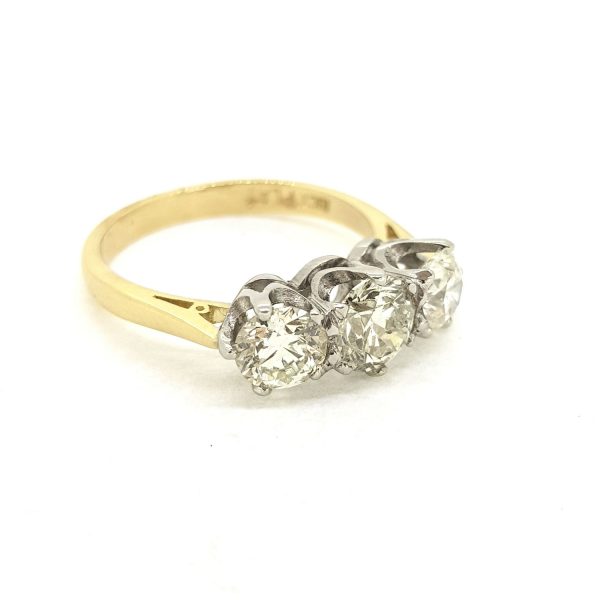 Classic Diamond Three Stone Ring, 1.80 carat total, three round brilliant-cut diamonds claw-set in platinum, mounted to a plain 18ct yellow gold band