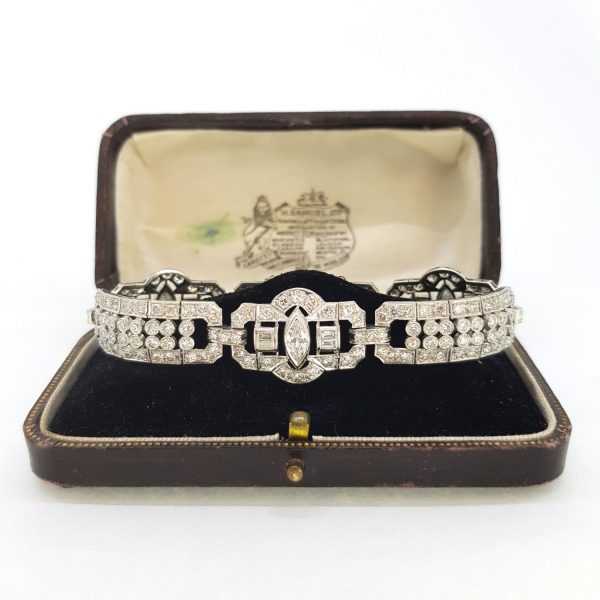 Art Deco Platinum and Diamond Bracelet, 12 carat total, platinum geometric panels and links set with sparkling diamonds around a baguette and marquise-cut diamond centre, Circa 1930